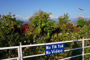 TikTok- und Videoverbot an der Weltfriedenspagode in Pokhara, Nepal, da Social-Media-Aufnahmen vor der Bergkulisse die Gebetsruhe stören.