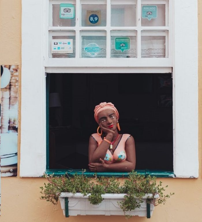 Afrobrasilianische Frau am Fenster bei Tag